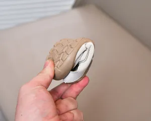 Macro detail of flexible non-slip brown rubber sole on white baby toddler shoes