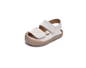 Macro detail of toddler closed-toe sandals featuring double hook-and-loop straps and rubber toe