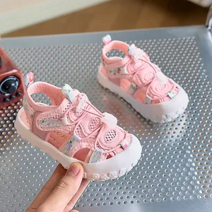 Dettaglio di sandali rosa per bambini con punta in gomma protettiva e motivo floreale