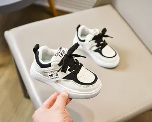 Détail de baskets classiques noires et blanches pour enfants avec semelles en caoutchouc