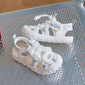Dettaglio di sandali in mesh per bambini con punta protettiva bianca e cinturini floreali