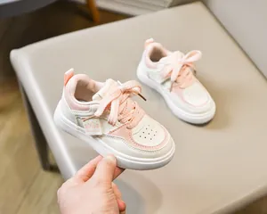 Détails latéraux de baskets enfant rose et blanc avec perforations et étiquette logo