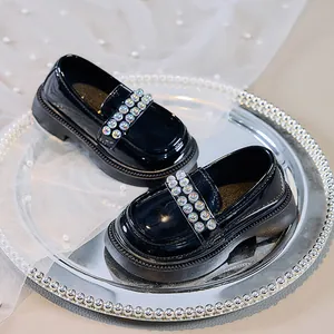 Detail von Mädchen Loafers aus schwarzem Lackleder mit Perlenriemen und dicker Sohle
