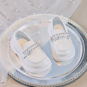 Detailansicht der weißen Mädchen-Lederhalbschuhe mit schimmernden Nietenverzierung