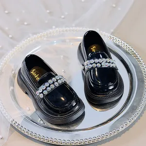 Nahaufnahme schwarzer Lackleder-Loafer für Mädchen mit eleganten Perlenriemendetails