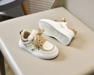 Détail de chaussures pour enfants beige et kaki avec lacets et étiquette 2025