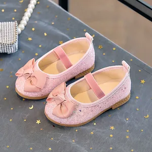 Detail of pink sequin girls' flats with large ribbon bow on starry mesh background