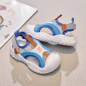 Detailed side view of kids sandals showing grey mesh fabric and orange pull tab details