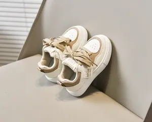 Détail de baskets pour enfants avec empiècements crème et marron et lacets plats