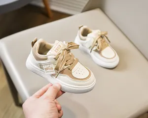 Gros plan de baskets en cuir beige pour enfants avec surpiqûres et semelles antidérapantes