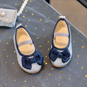 Detail of silver sequin Mary Jane flats featuring a contrast dark blue grosgrain bow