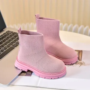 Dettaglio dello stivaletto a calza rosa in maglia per bambini con spessa suola antiscivolo