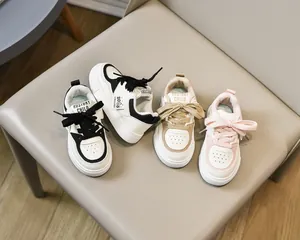 Détail des baskets en cuir pour enfants en blanc, marron et rose, style décontracté