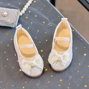 Close-up of glitter girls princess shoes with large ribbon bow and elastic strap details