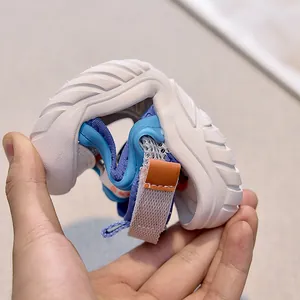 Close-up of flexible rubber sole on breathable mesh kids sandals being folded by hand