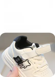 Dettagli di sneakers bianche per bambini con simpatico orsetto e chiusura a strappo
