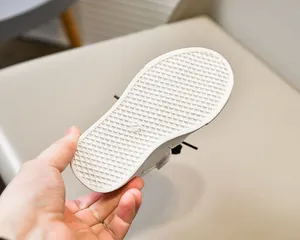 Gros plan sur la semelle gaufrée antidérapante des baskets blanches pour enfants