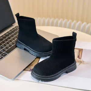 Dettaglio della trama in maglia nera e suola in gomma antiscivolo degli stivali per bambini