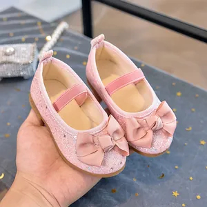 Detailed shot of pink sequined girls Mary Jane shoes with a large grosgrain bow