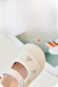 Detail der Baby-Mary-Jane-Schuhe mit breiter Antikollisionskappe und cremefarbenem Kunstleder