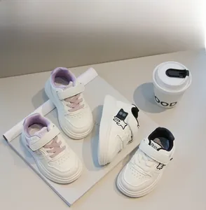 Dettaglio di sneaker in pelle per bambini con cinturino in velcro e motivi a cartoni