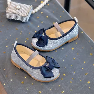 Detail of girls' sequin Mary Jane shoes with blue ribbon bow and star mesh background