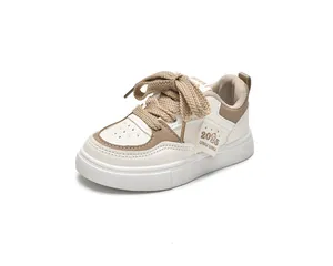 Détail de chaussures blanches pour enfants avec lacets tissés larges et cuir souple