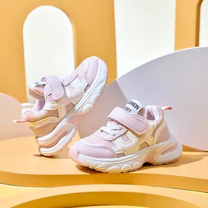 Detail of pink and white breathable mesh kids sneakers with Velcro straps and thick MD sole