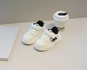 Dettaglio delle sneakers bianche in pelle per bambini con orsetto e velcro