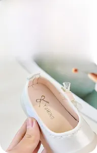 Détail de la chaussure de princesse bébé avec nœud en dentelle et bords ondulés