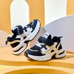 Detail of breathable mesh upper and Velcro strap on kids' black and white sneakers