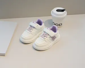 Dettaglio scarpe bianche bimbi con lacci viola e decorazione con orsetto carino