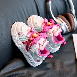 Detail of kids sneaker with 3D floral accent and pink wide laces on leather background