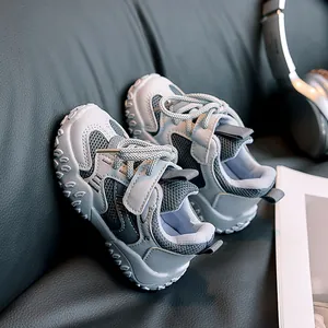 Detail view of breathable grey blue mesh kids sneakers with Velcro strap on leather background