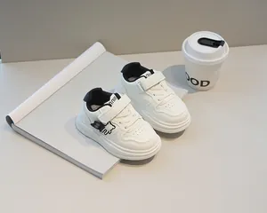 Dettaglio scarpe bianche bimbo con chiusura a strappo e simpatico motivo di orso nero