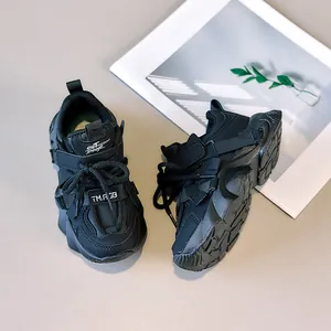 Detail of black children's chunky sneakers with textured anti-slip sole and velcro strap