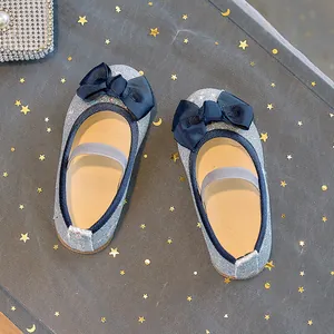 Detail of girls' blue sequin princess shoes with satin bow and elastic strap on starry mesh