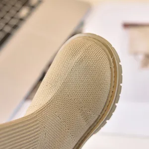 Dettaglio di stivaletti in maglia beige con trama del tessuto e suola in gomma spessa