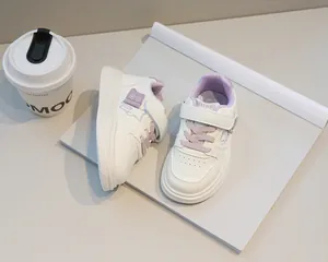 Dettaglio di scarpe bianche per bambini con accenti viola e chiusura a strappo comoda