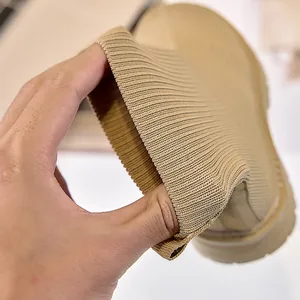 Dettaglio ravvicinato di stivaletti in maglia kaki con polsino a coste elasticizzato