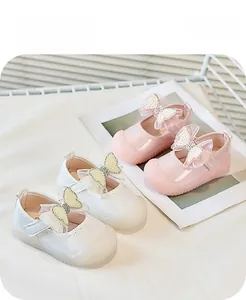 Vue de dessus de chaussures bébé roses et blanches avec nœud perlé et velcro