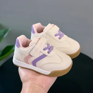 Détail de rayures roses et mauves sur chaussures bébé crème avec bride velcro