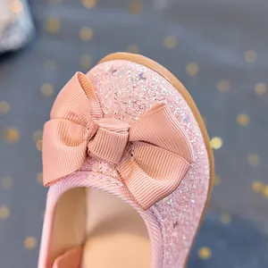 Close-up of pink sequin girl's princess shoes with a large glittery bow detail