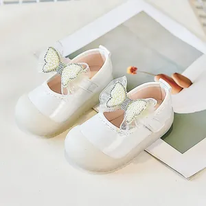 Détail de chaussures pour bébés blanches avec nœuds à perles et semelles antidérapantes