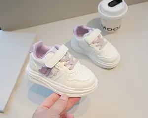 Dettaglio scarpe da ginnastica bimbi con suola morbida e decorazione orsetto viola
