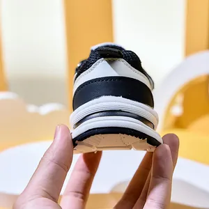 Detail of breathable mesh and thick anti-slip sole on black and white kids sneakers