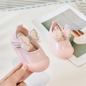 Détail de chaussures de princesse roses avec nœud en maille, perles et strass brillants