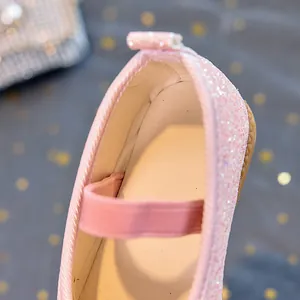Macro detail of pink sequins and elastic strap on girls princess Mary Jane shoes