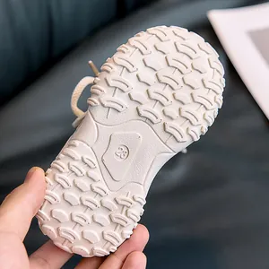 Detailed view of non-slip rubber sole with size 28 stamp on kids sports shoes