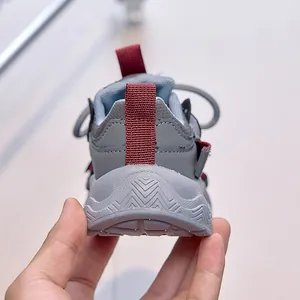 Detailed view of children's sneakers with anti-slip wave pattern soles and double heel pull tabs